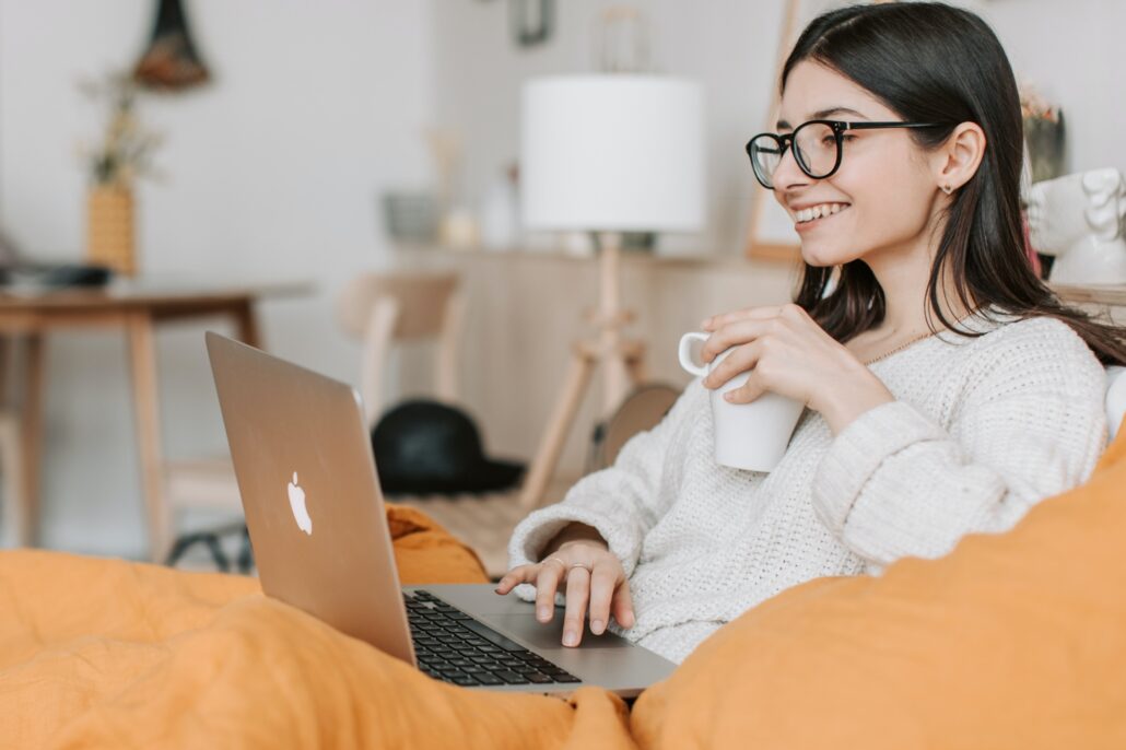 woman looking at her computer while drinking coffee - seeking eating disorder recovery